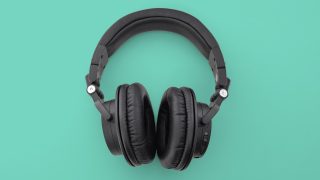 View from top of black Audio Technica ATH-M50XBT headphones kept on a green background