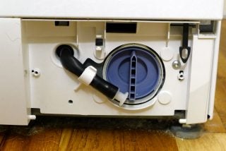 The emergency drain hose, door release and pump access cover on a Bosch washing machine