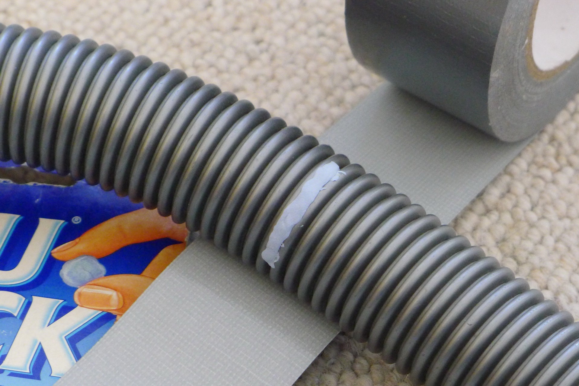 Patching a vacuum hose with Blu Tak and masking tape
