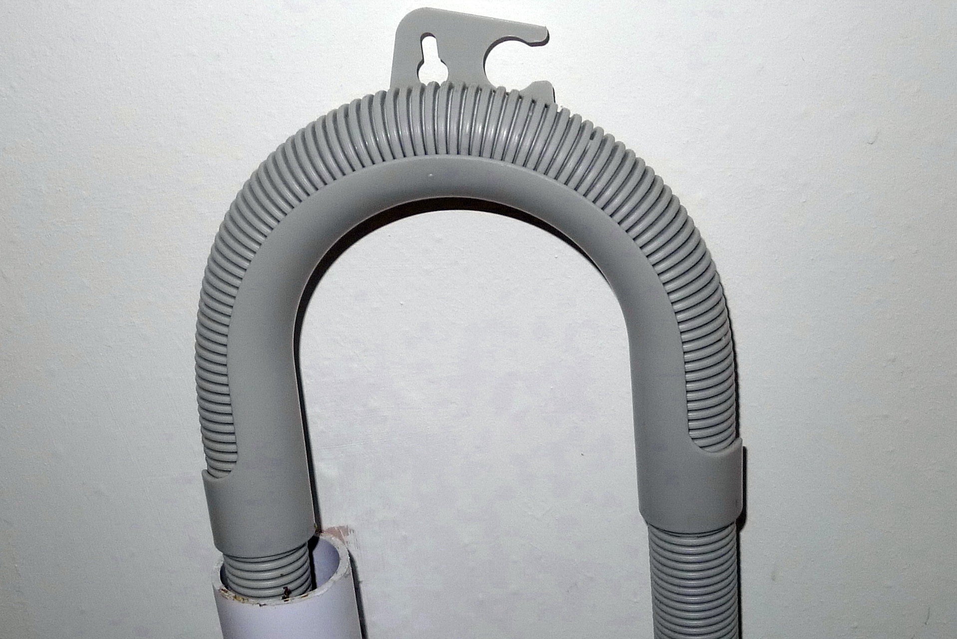 A washing machine drain hose guide above the standpipe