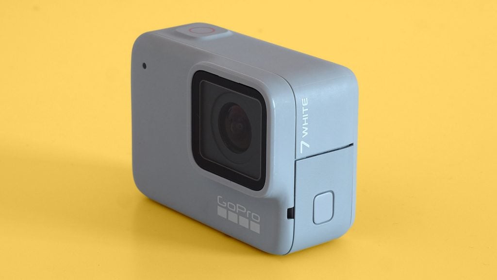 Right angled view of a GoPro Hero7 white standing on a yellow background