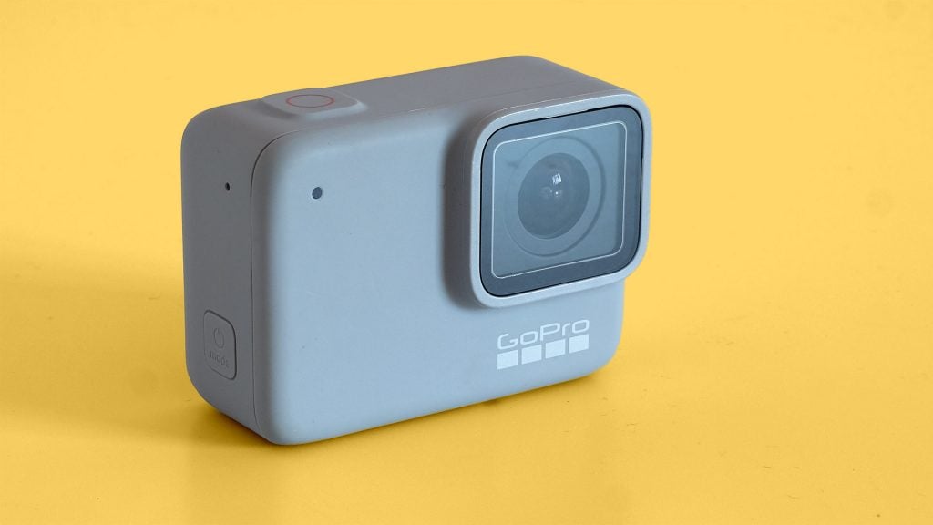 Left angled view of a GoPro Hero7 white standing on a yellow background