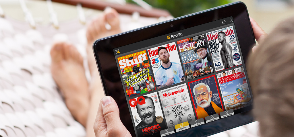 A black tablet held in hand displaying Readly's magazines section screen