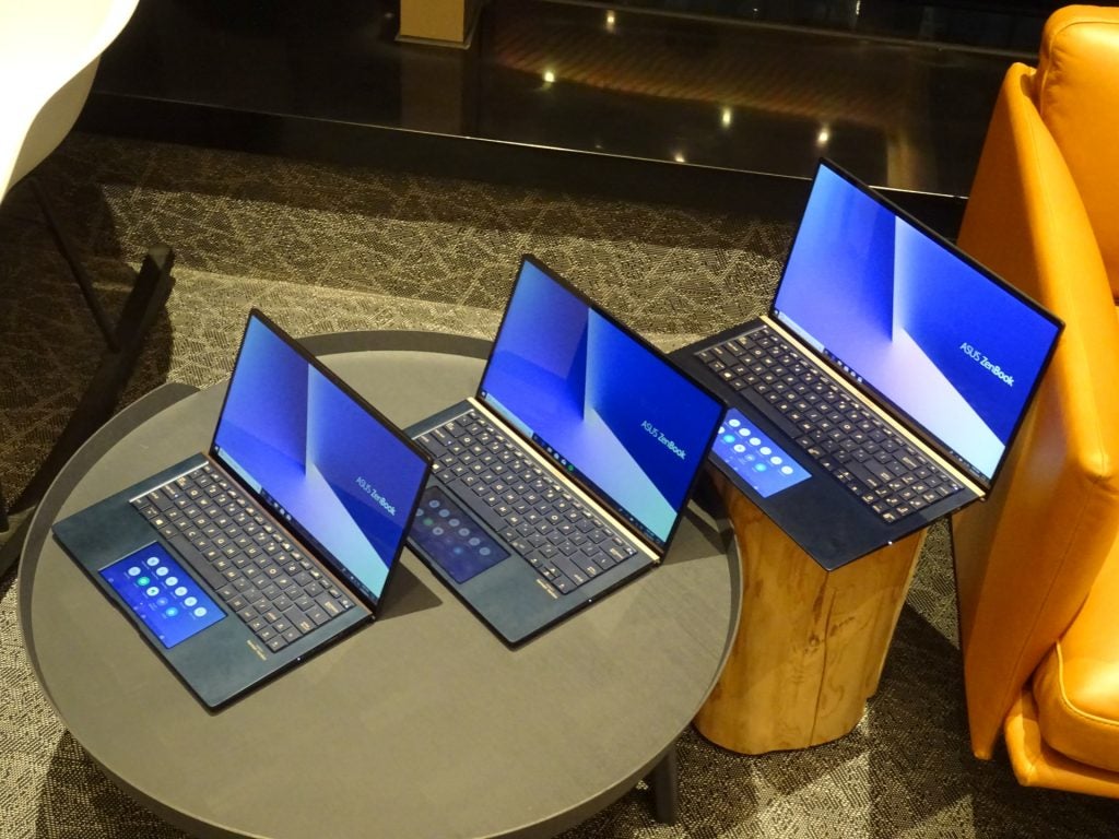 Right angled view from top of three Asus Zenbook 2019 kept on a table displaying homescreen