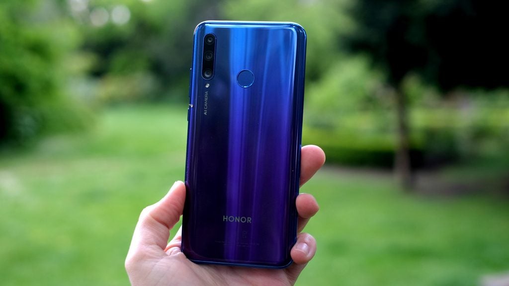 Back panel view of a blue Honor 20 Lite held in hand facing back