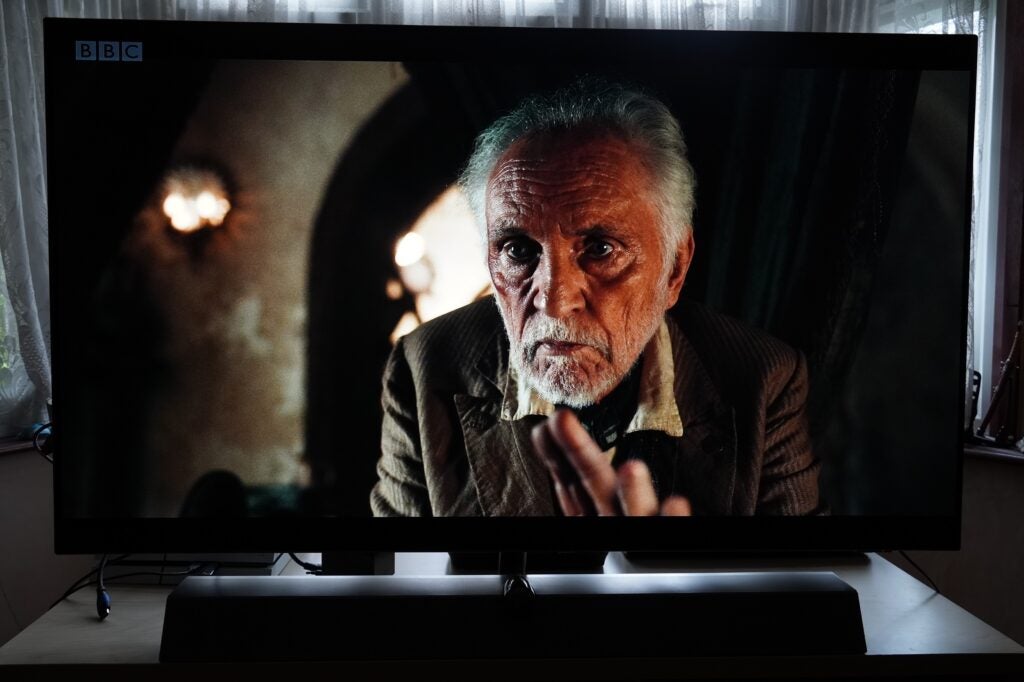 A black Philips OLED, streaming a scene from a movie via Freeview