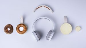 View from top of white Korvaa headphones kept disassembled on a blue background