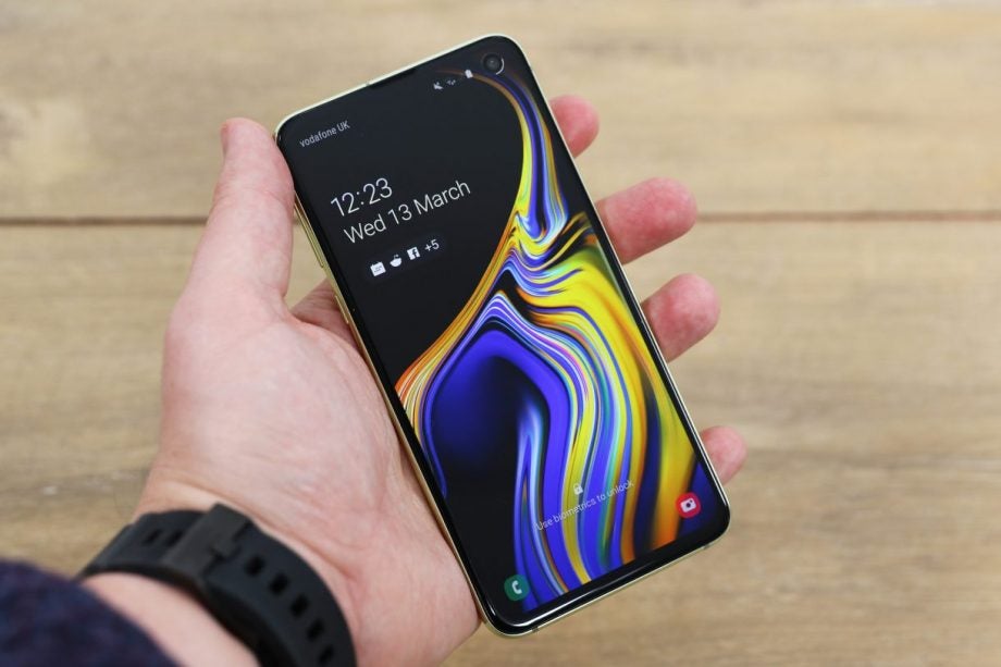 A Samsung Galaxy S10e held in hand displaying lock screen