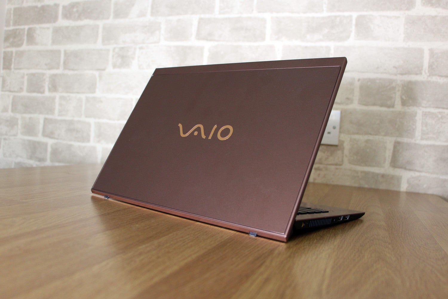 Right angled back panel view of a brown Vaio SX14 laptop kept on a table
