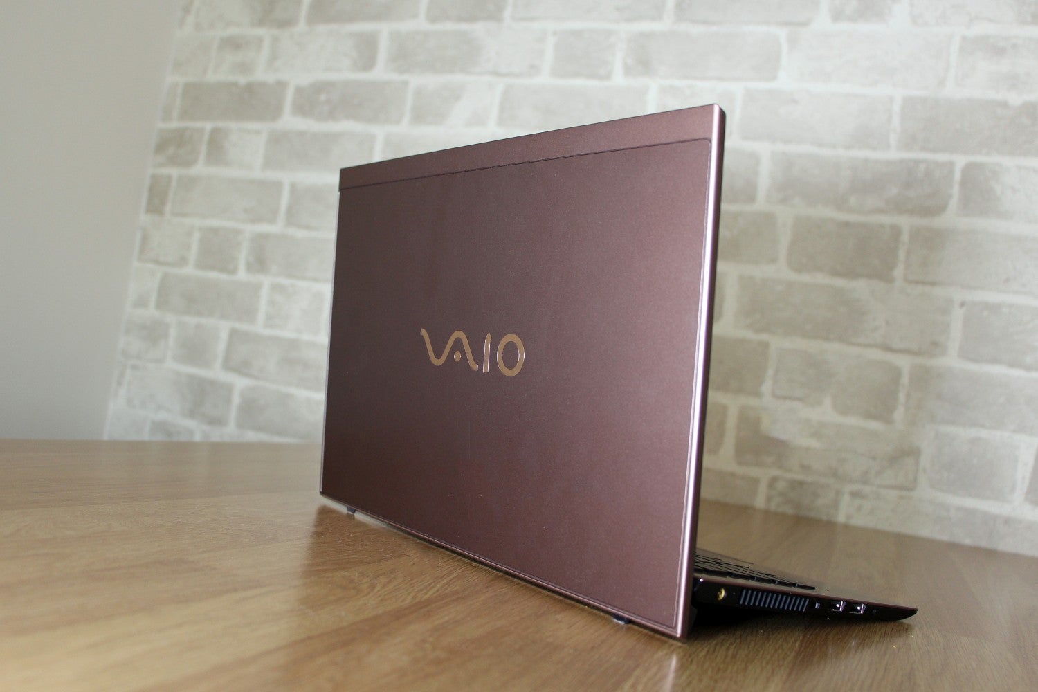 Right angled back panel view of a brown Vaio SX14 laptop kept on a table