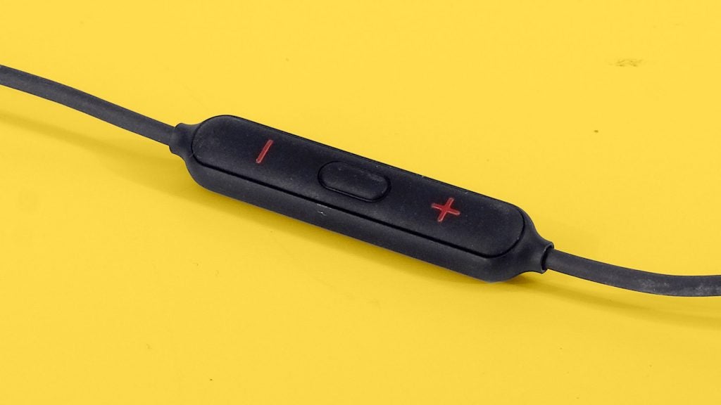 OnePlus Bullets Wireless 2Close up view of OnePlus Bullets wireless 2 earphones's buttons section kept on a yellow background