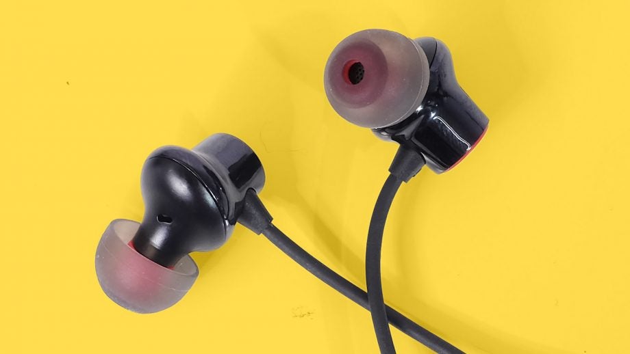 Close up view of OnePlus Bullets wireless 2 earphones's earbuds kept on a yellow background