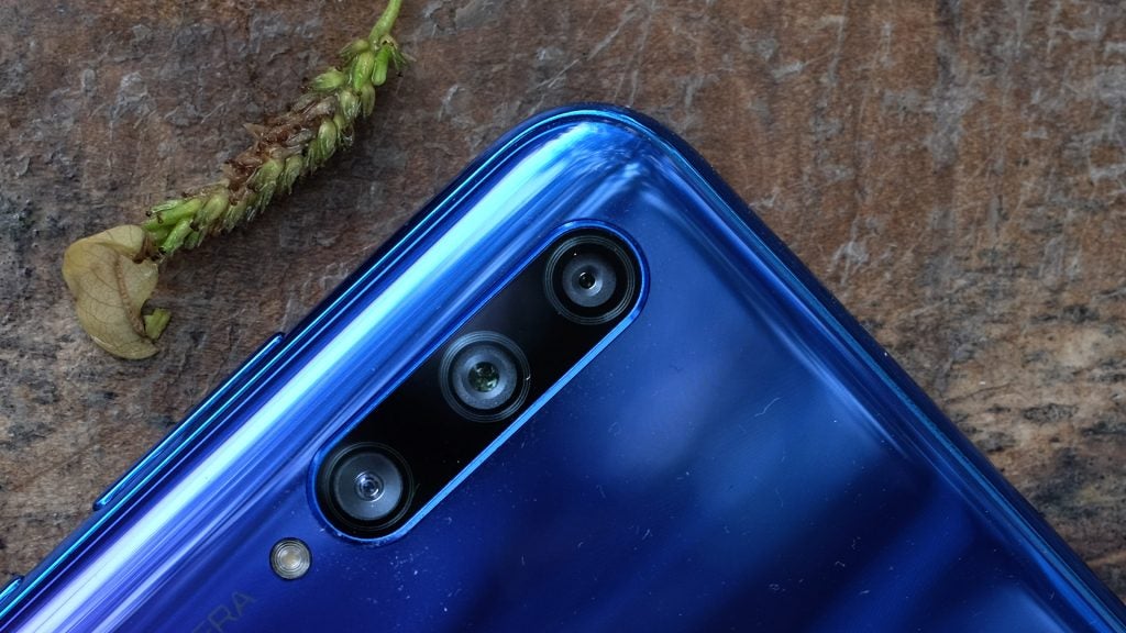 Close up view of back camera section of a blue Honor 20 Lite kept facing on a wooden surface