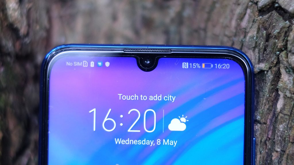 Top half view of a blue Honor 20 Lite displaying time on homescreen