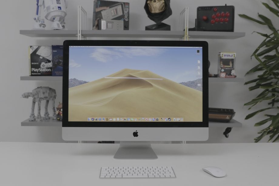 A white table with an iMac, a keyboard and a mouse kept on it