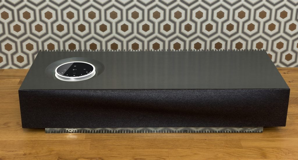 Side view of a black Naim Mu So 2 music system kept on a wooden table