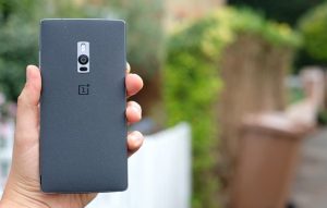 Back panel view of a black OnePlus 2 smartphone held in hand facing back
