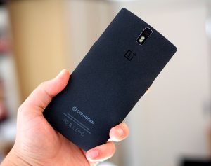 Back panel view of a black OnePlus 1 smartphone held in hand facing back