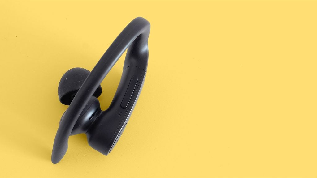 Powerbeats ProClose up view of a black Powerbeats earbud kept on a yellow background