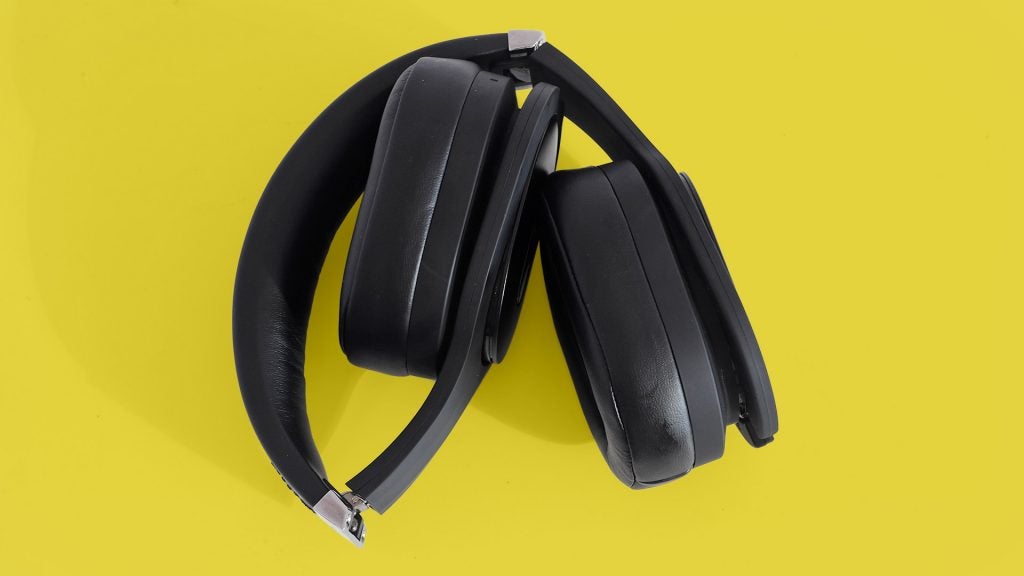 PSB M4U 8View from top of black PSB headphones kept on a yellow background with earcups folded