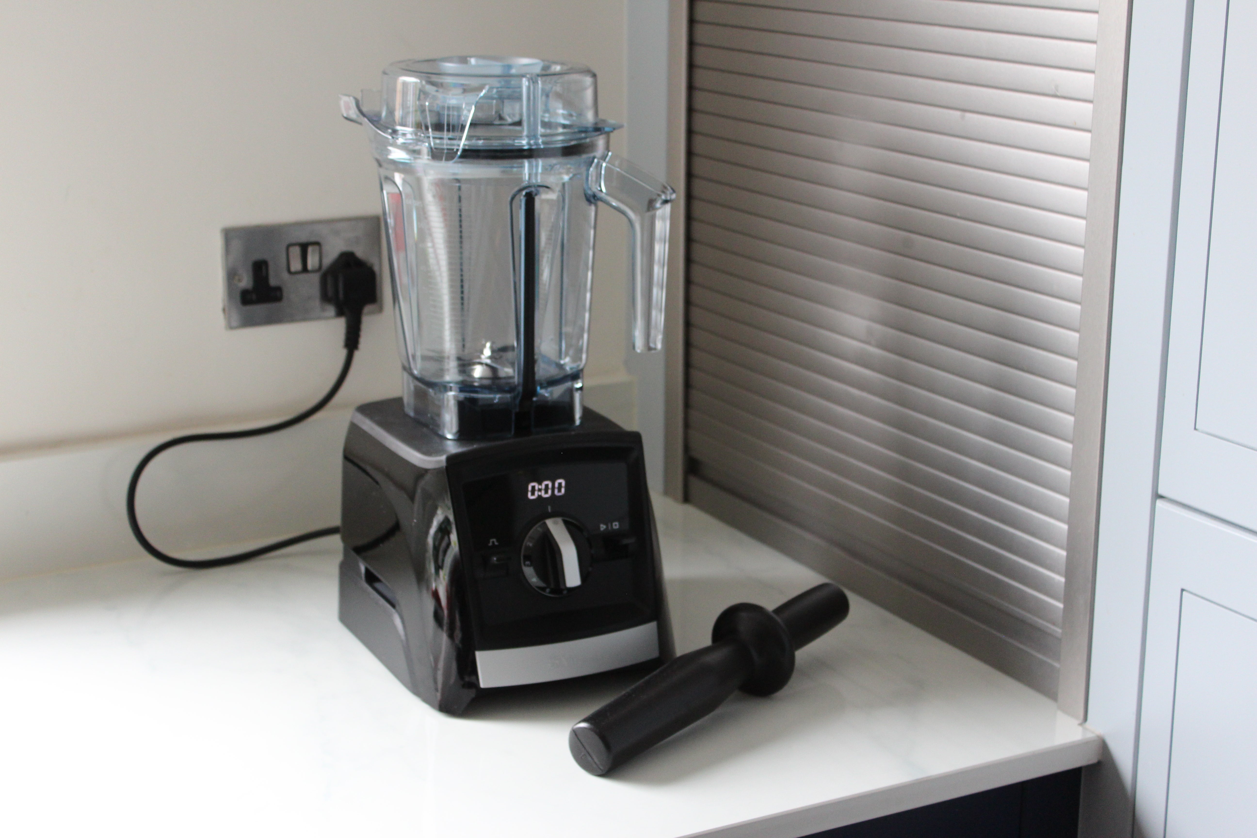 A Vitamix A2300i belnder kept on a table with it's empty jar fixed on top
