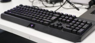 Bottom right angled view of a black Razer keyboard kept on a white table