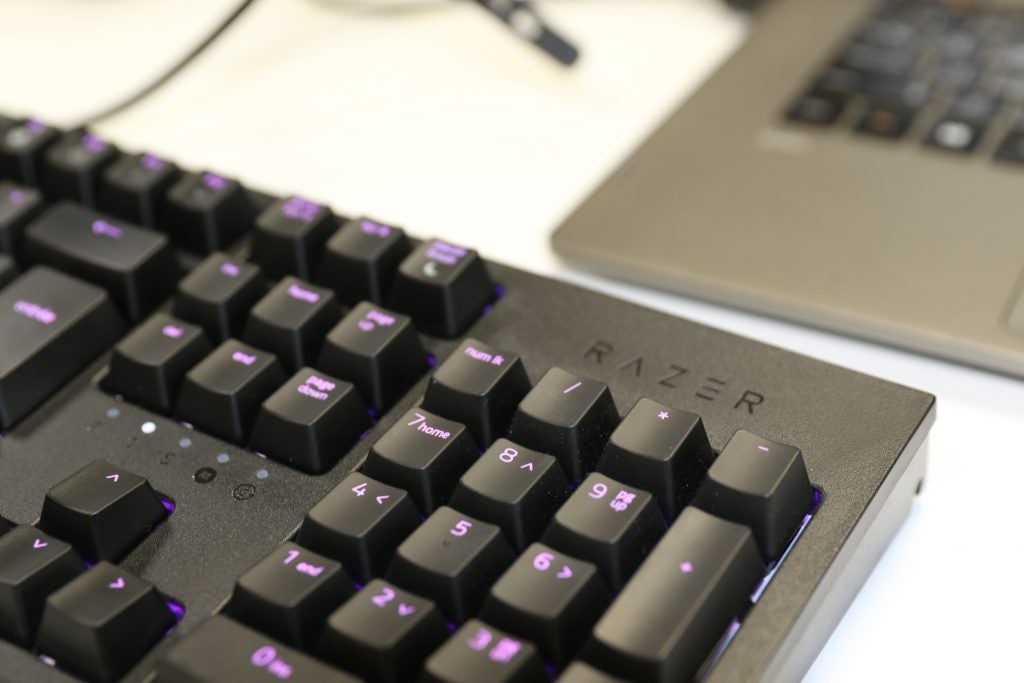 Close up view of numpad of a black Razer keyboard kept on a white table