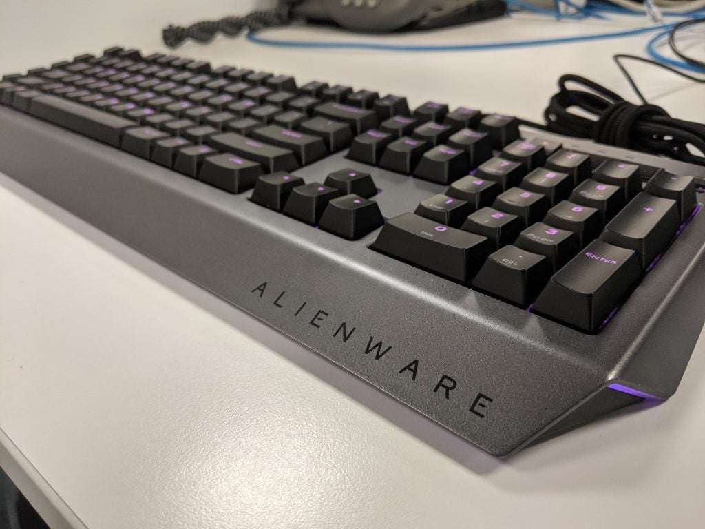 Bottom-right angled view of a gray-black Alienware keyboard kept on a white table