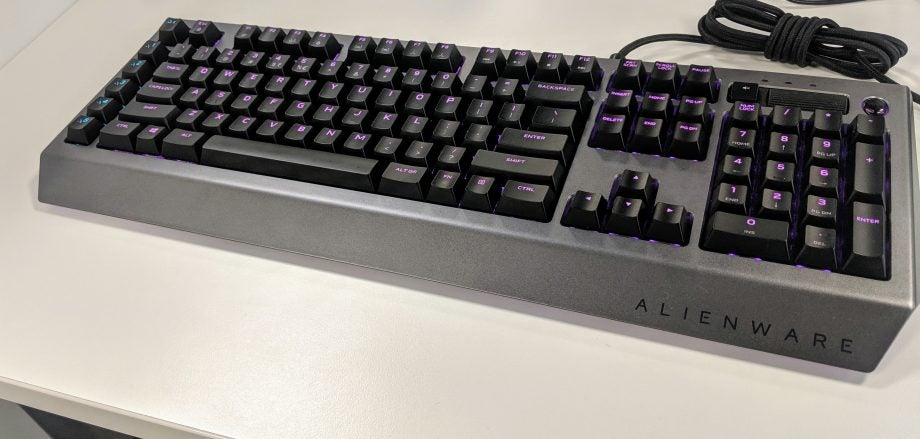 Bottom angled view of a gray-black Alienware keyboard kept on a white table