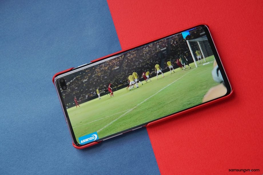 View from top of inside view of a Samsung Galaxy S10 Plus kept on a red-blue background displaying a live match