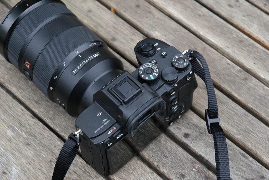 Top-back view of a black Sony A 7R standing on a wooden surface