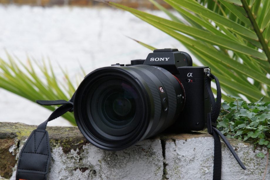 Rigth angled view of a black Sony A 7R kept on a wall with lens attached