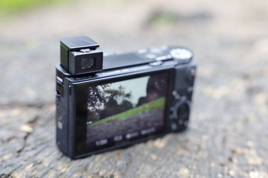 Back panel view of a black Sony RX100 VII camera standing on ground