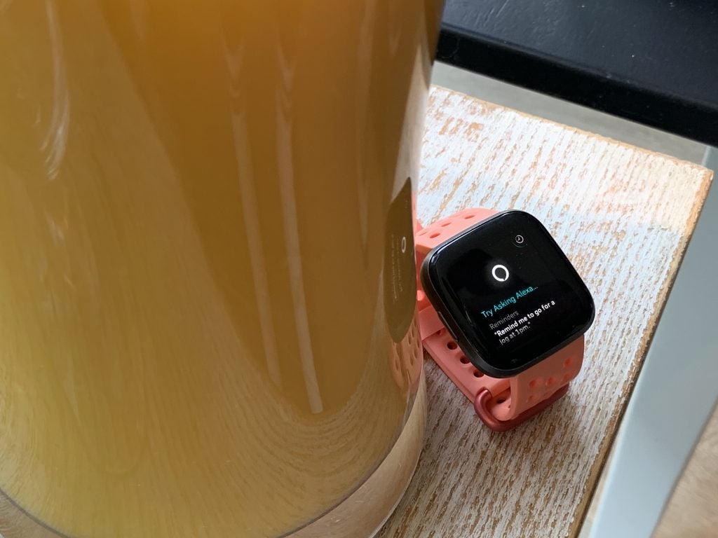 Side view of a Fitbit Versa 2 wore on hand displaying activities