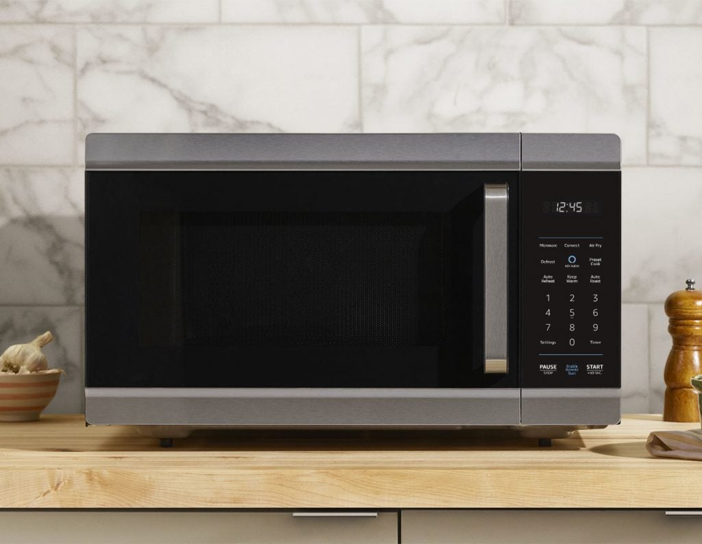 A gray-black Alexa smart oven kept on a wooden table