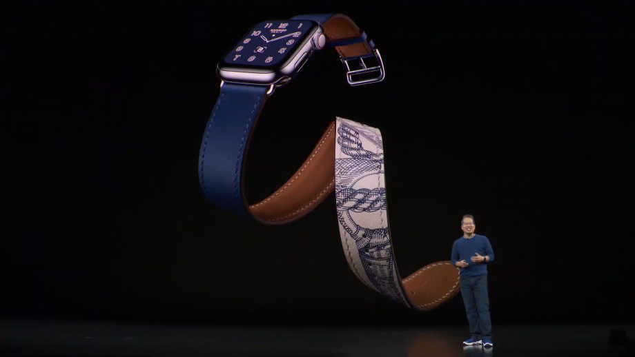A man standing on stage with a blue Apple Watch series 5 displayed on the screen behind