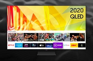 A gray 2020 QLED TV standing on a black background displaying homescreen