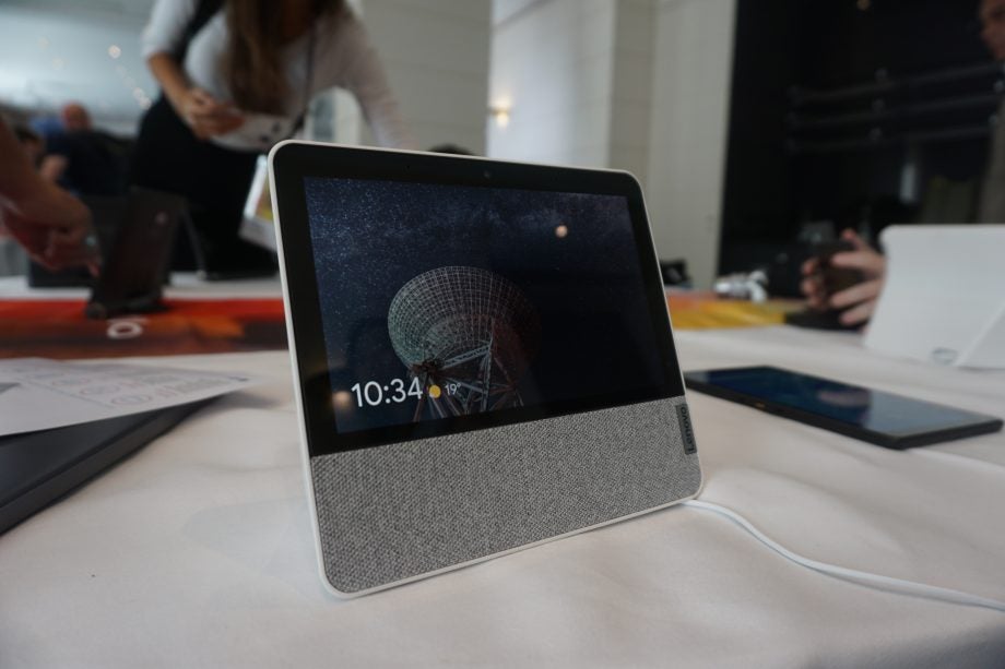 Left angled view of a Lenovo Smart Display 7 standing on a white table displaying lock screen