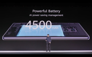 A man standing on stage with Huawei Mate 30's 4500mAh battery displayed on screen behind