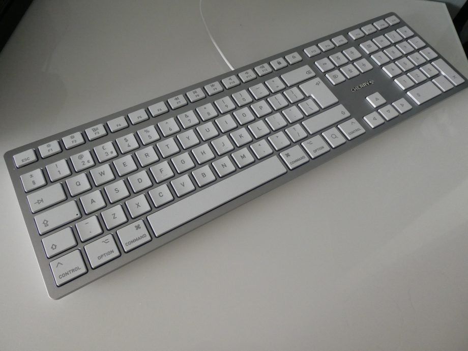 Left angled view of a silver-white Cherry keyboard kept on a table