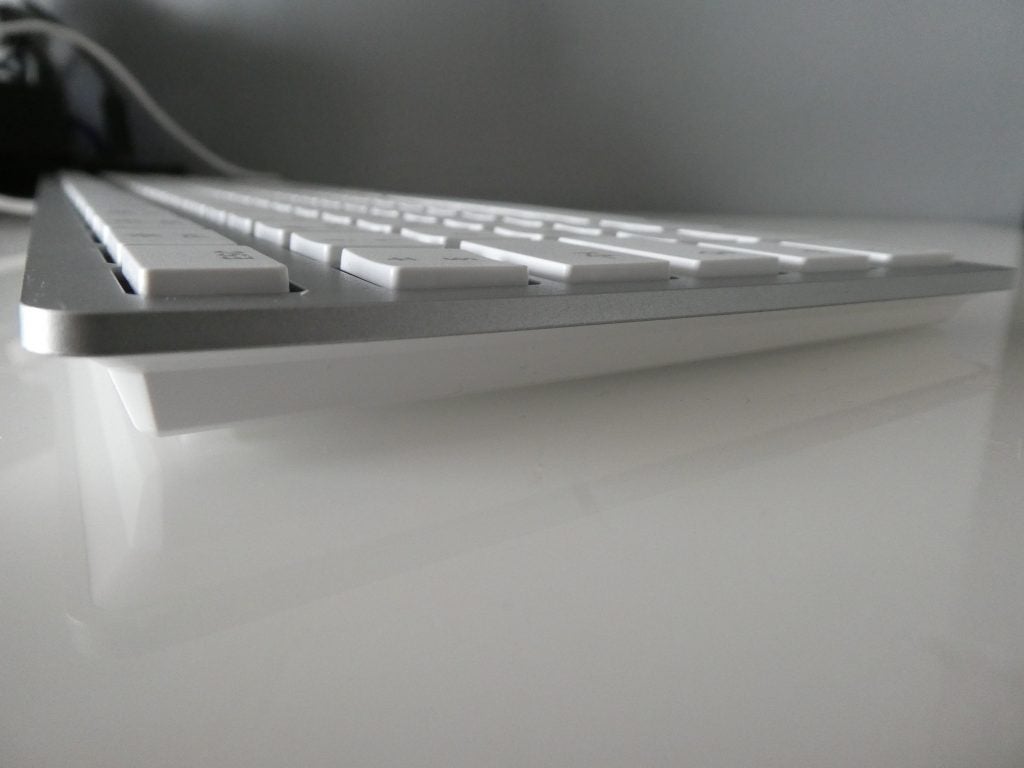 Left side edge view of a silver-white Cherry keyboard kept on a table