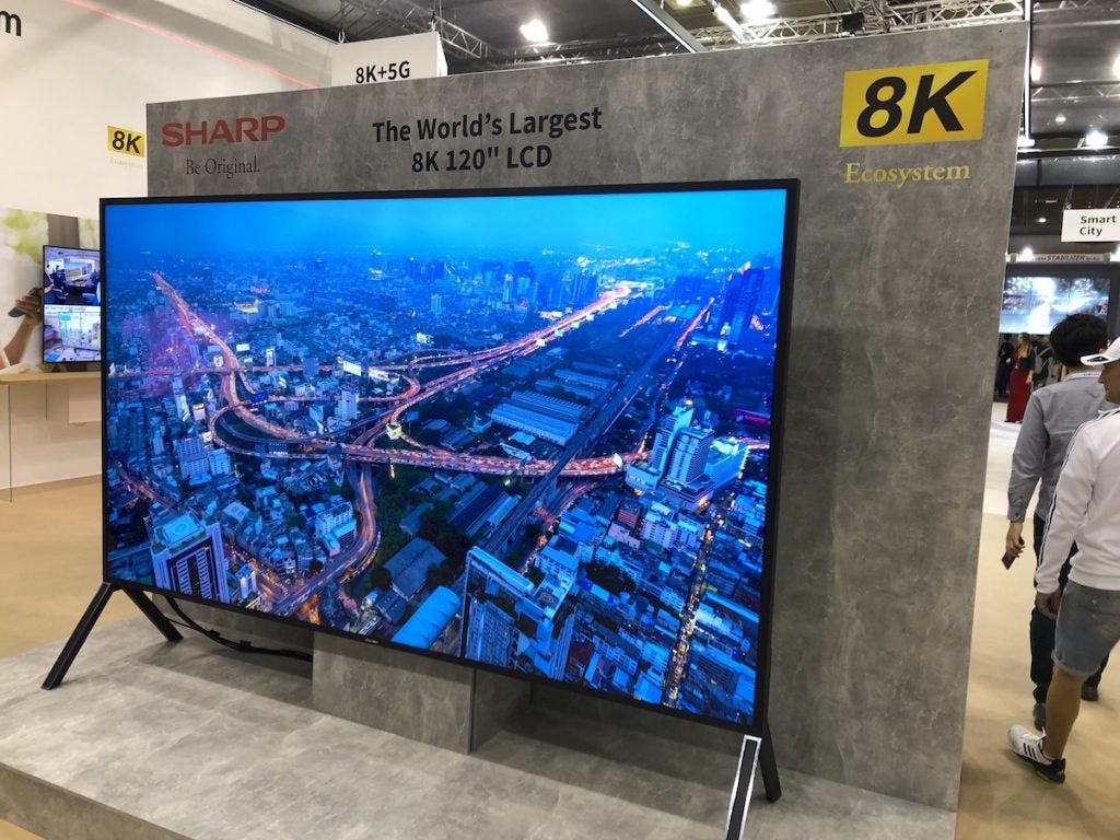 Sharp 120-inch 8K TVRight angled view of a black Sharp 120-in 8K TV standing on it's stand in a store