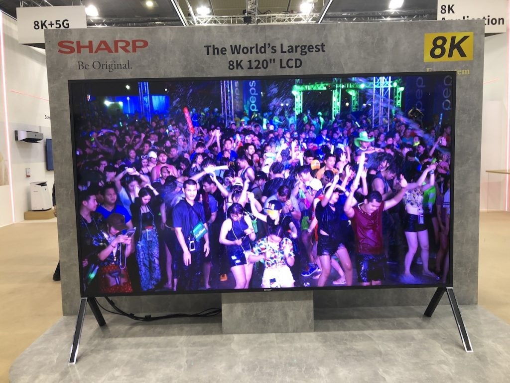 Sharp 120-inch 8K TVA black Sharp 120-in 8K TV standing on it's stand in a store