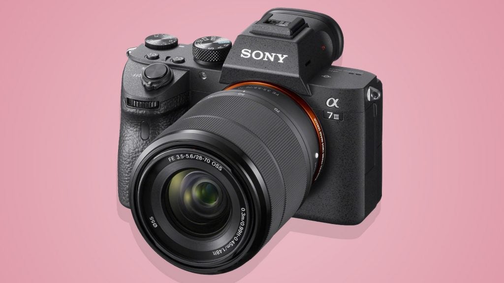 Right angled view of a black Sony Alpha 7 III camera standing on a pink backgroundRight angled view of a black Sony Alpha 7 camera standing on a purple background