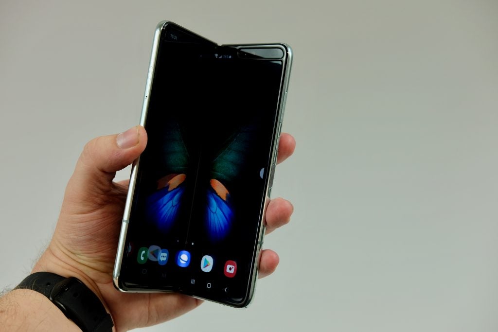 A Samsung Galaxy Fold held in hand in half folded state