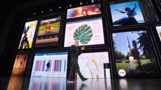 Tim Cook standing on stage with iPad OS features displayed on screen behind
