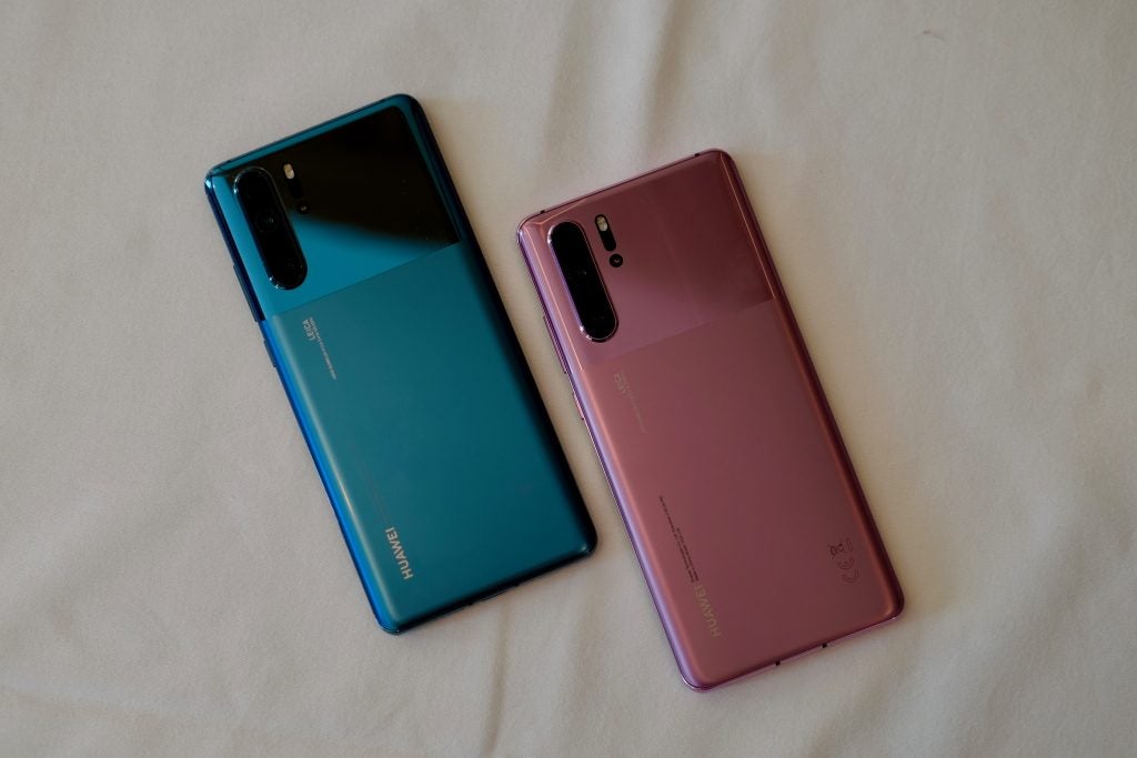 Two different colored Huawei P30 Pro kept on a white background facing down, back panel view