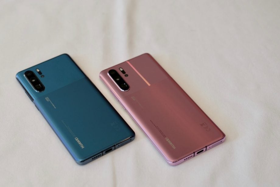 Two different colored Huawei P30 Pro kept on a white background facing down, back panel view
