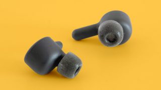 Black RHA earbuds kept on a yellow background