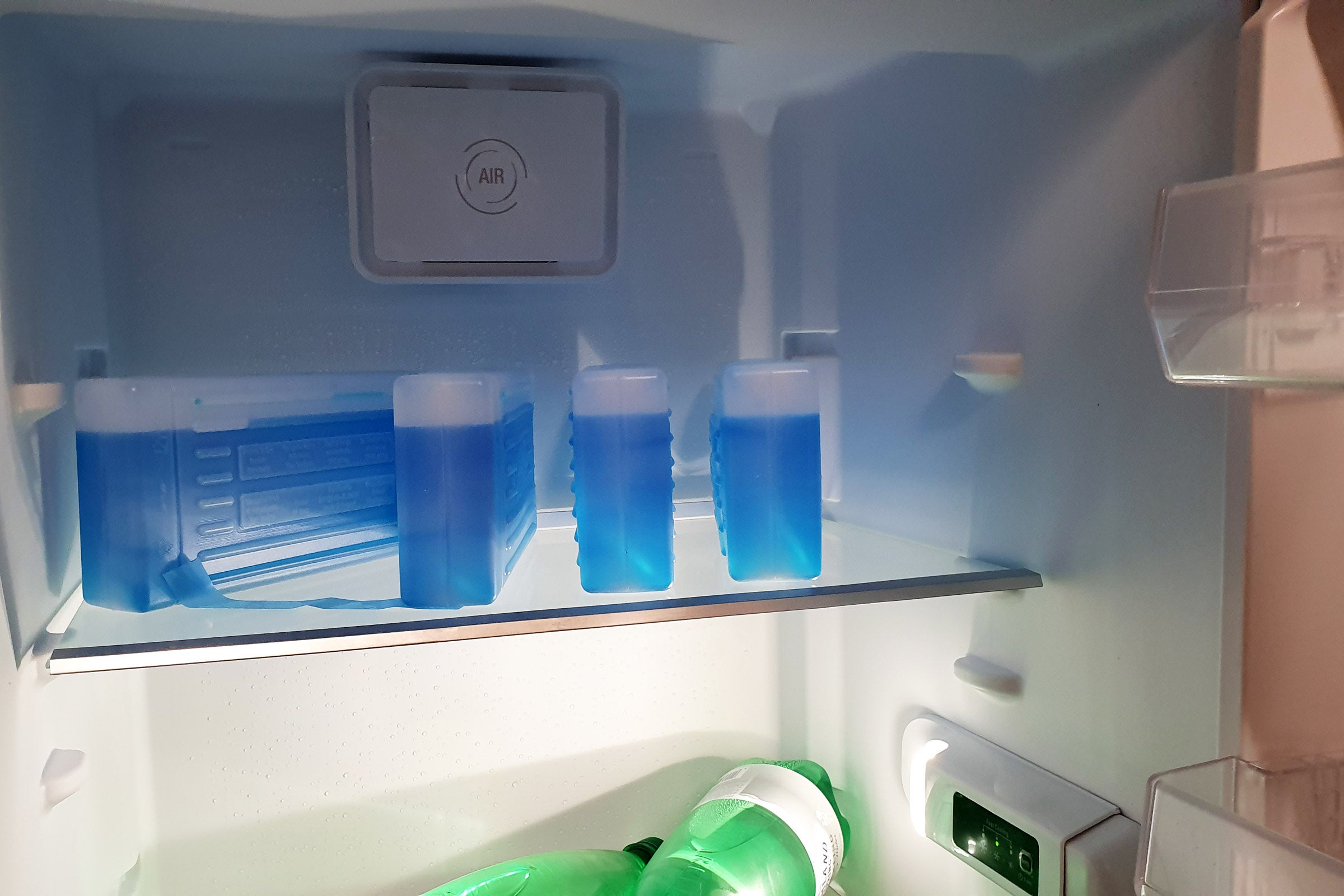Inside view of trays of a fridge with bottles laid on them